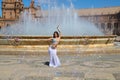 A young and beautiful belly dancer dancing in a square. She is dressed in light blue with a white veil in her hands. World Royalty Free Stock Photo