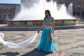 A young and beautiful belly dancer dancing in a square. She is dressed in light blue with a white veil in her hands. World Royalty Free Stock Photo