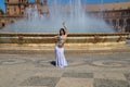 A young and beautiful belly dancer dancing in a square. She is dressed in light blue with a white veil in her hands. World Royalty Free Stock Photo