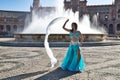 A young and beautiful belly dancer dancing in a square. She is dressed in light blue with a white veil in her hands. World Royalty Free Stock Photo