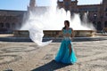 A young and beautiful belly dancer dancing in a square. She is dressed in light blue with a white veil in her hands. World Royalty Free Stock Photo