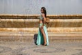 A young and beautiful belly dancer dancing in a square. She is dressed in light blue with a white veil in her hands. World Royalty Free Stock Photo