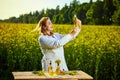 A young beautiful biologist or agronomist examines the quality of rapeseed oil on a rape field. Agribusiness concept Royalty Free Stock Photo