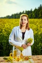 A young beautiful biologist or agronomist examines the quality of rapeseed oil on a rape field. Agribusiness concept Royalty Free Stock Photo