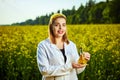 A young beautiful biologist or agronomist examines the quality of rapeseed oil on a rape field. Agribusiness concept Royalty Free Stock Photo