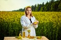A young beautiful biologist or agronomist examines the quality of rapeseed oil on a rape field. Agribusiness concept Royalty Free Stock Photo