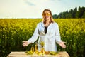 A young beautiful biologist or agronomist examines the quality of rapeseed oil on a rape field. Agribusiness concept Royalty Free Stock Photo