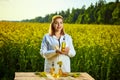 A young beautiful biologist or agronomist examines the quality of rapeseed oil on a rape field. Agribusiness concept Royalty Free Stock Photo