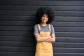 Young happy smiling afro girl with curly hair standing on black wall background.