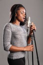Young beautiful black woman singing in microphone Royalty Free Stock Photo