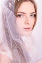 Young beautiful blond fiancee portrait with white veil.