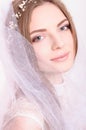 Young beautiful blond fiancee portrait with white veil.