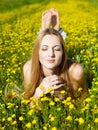 Young beautiful blond girl laying on the daisy flowers field Royalty Free Stock Photo