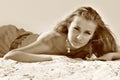 Young beautiful blond slim woman in beach clothing lying on sand