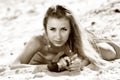 Young beautiful blond slim woman in beach clothing lying on sand