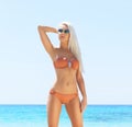 Young and beautiful blond woman posing in bikini on the beach. Fit and sexy fashion model in swimsuit. Royalty Free Stock Photo