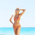 Young and beautiful blond woman posing in bikini on the beach. Fit and sexy fashion model in swimsuit. Royalty Free Stock Photo