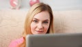 young beautiful blond woman sit on the sofa in livingroom hold tablet in arms Royalty Free Stock Photo