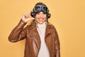 Young beautiful blonde aviator woman wearing vintage pilot helmet whit glasses and jacket smiling and confident gesturing with Royalty Free Stock Photo