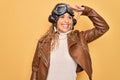 Young beautiful blonde aviator woman wearing vintage pilot helmet whit glasses and jacket very happy and smiling looking far away Royalty Free Stock Photo