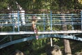 Young beautiful blonde on the bridge over river in the resort town of Belokurikha. Altai territory