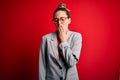 Young beautiful blonde businesswoman with blue eyes wearing glasses and jacket bored yawning tired covering mouth with hand Royalty Free Stock Photo