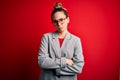 Young beautiful blonde businesswoman with blue eyes wearing glasses and jacket skeptic and nervous, disapproving expression on Royalty Free Stock Photo