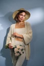 A young beautiful blonde caucasian woman with a short haircut in a beige suit and hat with bouquet of white flowers on Royalty Free Stock Photo