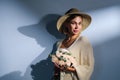 A young beautiful blonde caucasian woman with a short haircut in a beige suit and hat with bouquet of white flowers on Royalty Free Stock Photo