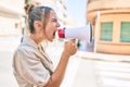 Young beautiful blonde caucasian woman smiling happy outdoors on a sunny day shouting through megaphone Royalty Free Stock Photo