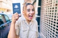 Young beautiful blonde caucasian woman smiling happy outdoors on a sunny day showing Australia passport Royalty Free Stock Photo