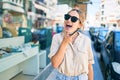 Young beautiful blonde caucasian woman smiling happy outdoors on a sunny day using smartphone Royalty Free Stock Photo