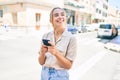 Young beautiful blonde caucasian woman smiling happy outdoors on a sunny day using smartphone Royalty Free Stock Photo