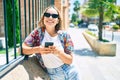 Young beautiful blonde caucasian woman smiling happy outdoors on a sunny day using smartphone Royalty Free Stock Photo