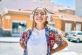 Young beautiful blonde caucasian woman smiling happy outdoors on a sunny day wearing headphones listening to music Royalty Free Stock Photo