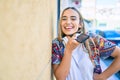 Young beautiful blonde caucasian woman smiling happy outdoors on a sunny day wearing headphones and using smartphone Royalty Free Stock Photo