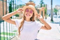 Young beautiful blonde caucasian woman smiling happy outdoors on a sunny day wearing summer hat and pink sunglasses Royalty Free Stock Photo