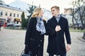 Young beautiful blonde couple walking city street, looking at each other with smile. Royalty Free Stock Photo