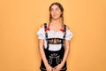 Young beautiful blonde german woman with blue eyes wearing traditional octoberfest dress smiling looking to the side and staring Royalty Free Stock Photo