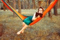 Young blonde girl in hammock reading book. Pretty woman leisure lifestyle at nature ountdoor. Female relax in forest. Royalty Free Stock Photo