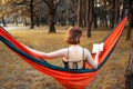 Young blonde girl in hammock reading book. Pretty woman leisure lifestyle at nature ountdoor. Female relax in forest. Royalty Free Stock Photo