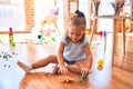 Young beautiful blonde girl kid enjoying play school with toys at kindergarten, smiling happy playing with dinosaurs toys at home