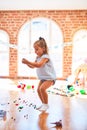 Young beautiful blonde girl kid enjoying play school with toys at kindergarten, smiling happy playing with dinosaurs toys at home