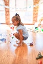 Young beautiful blonde girl kid enjoying play school with toys at kindergarten, smiling happy playing with dinosaurs toys at home