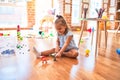 Young beautiful blonde girl kid enjoying play school with toys at kindergarten, smiling happy playing with dinosaurs toys at home