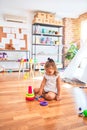 Young beautiful blonde girl kid enjoying play school with toys at kindergarten, smiling happy playing with inteligence toys at