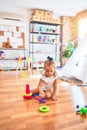 Young beautiful blonde girl kid enjoying play school with toys at kindergarten, smiling happy playing with inteligence toys at