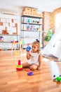 Young beautiful blonde girl kid enjoying play school with toys at kindergarten, smiling happy playing with inteligence toys at