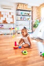 Young beautiful blonde girl kid enjoying play school with toys at kindergarten, smiling happy playing with inteligence toys at