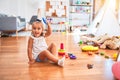 Young beautiful blonde girl kid enjoying play school with toys at kindergarten, smiling happy playing with inteligence toys at